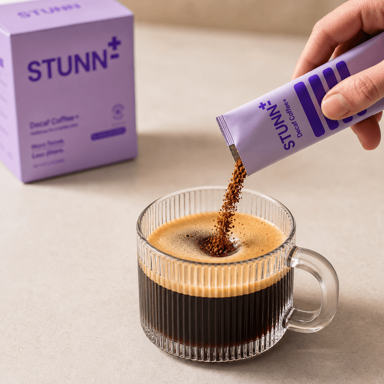 STUNN sachet being poured into a glass mug of coffee